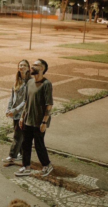 Matheus e Ana falando para jovens sentados numa praça à noite